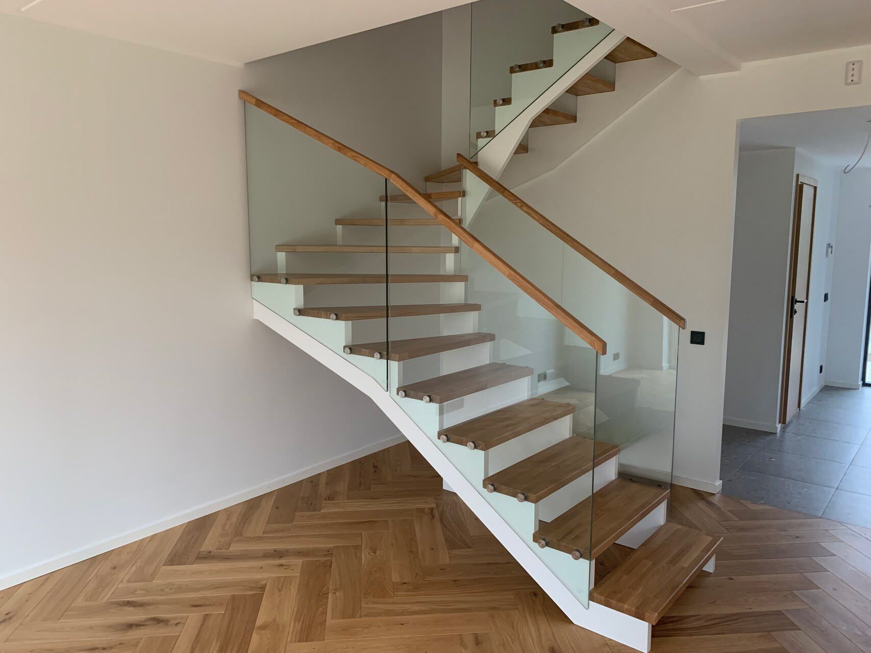 16. A modern U-shaped staircase with a stringer board and a glass railing