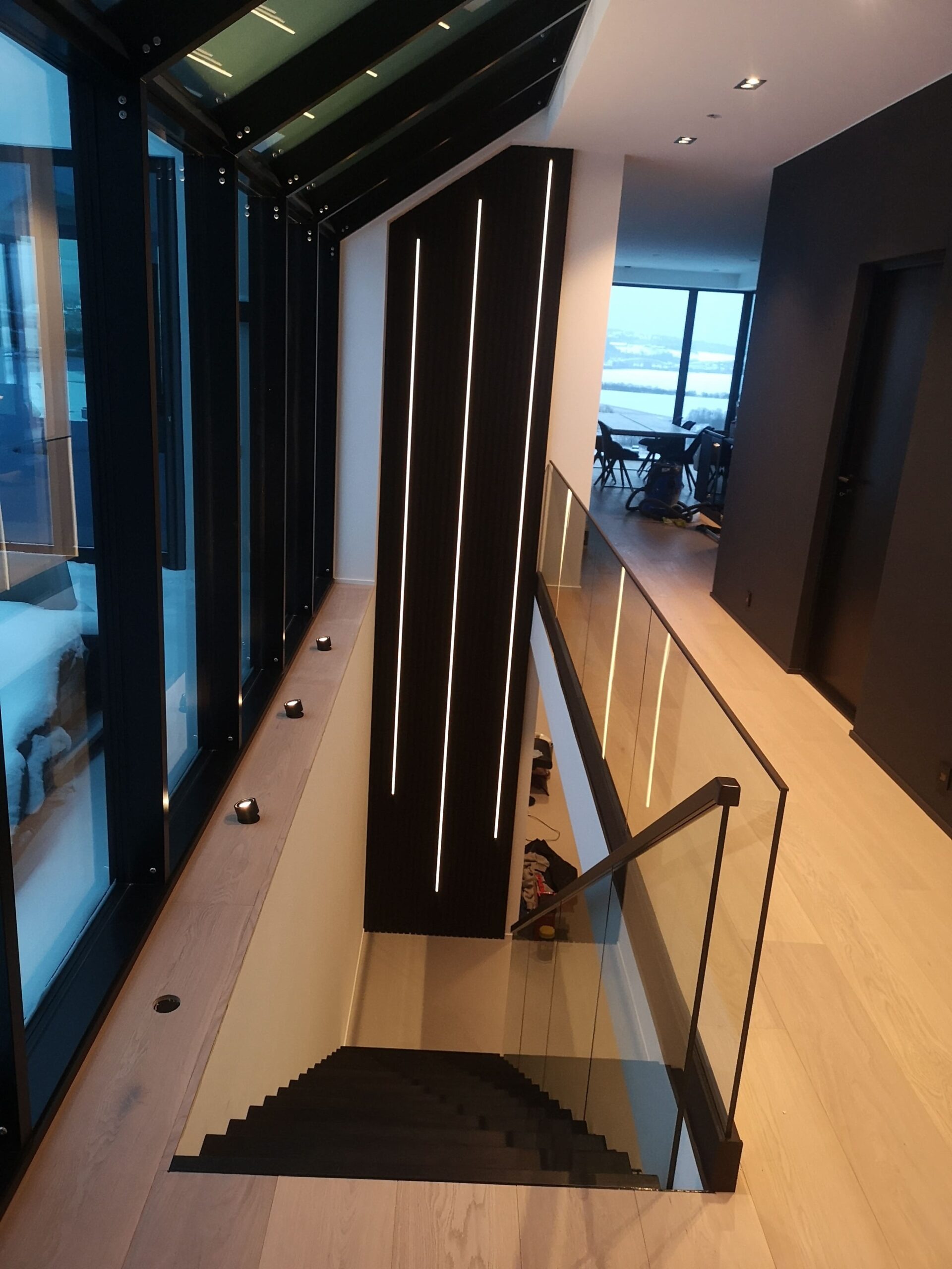 05. Black staircase with a wooden beam, a glass railing and floor railing