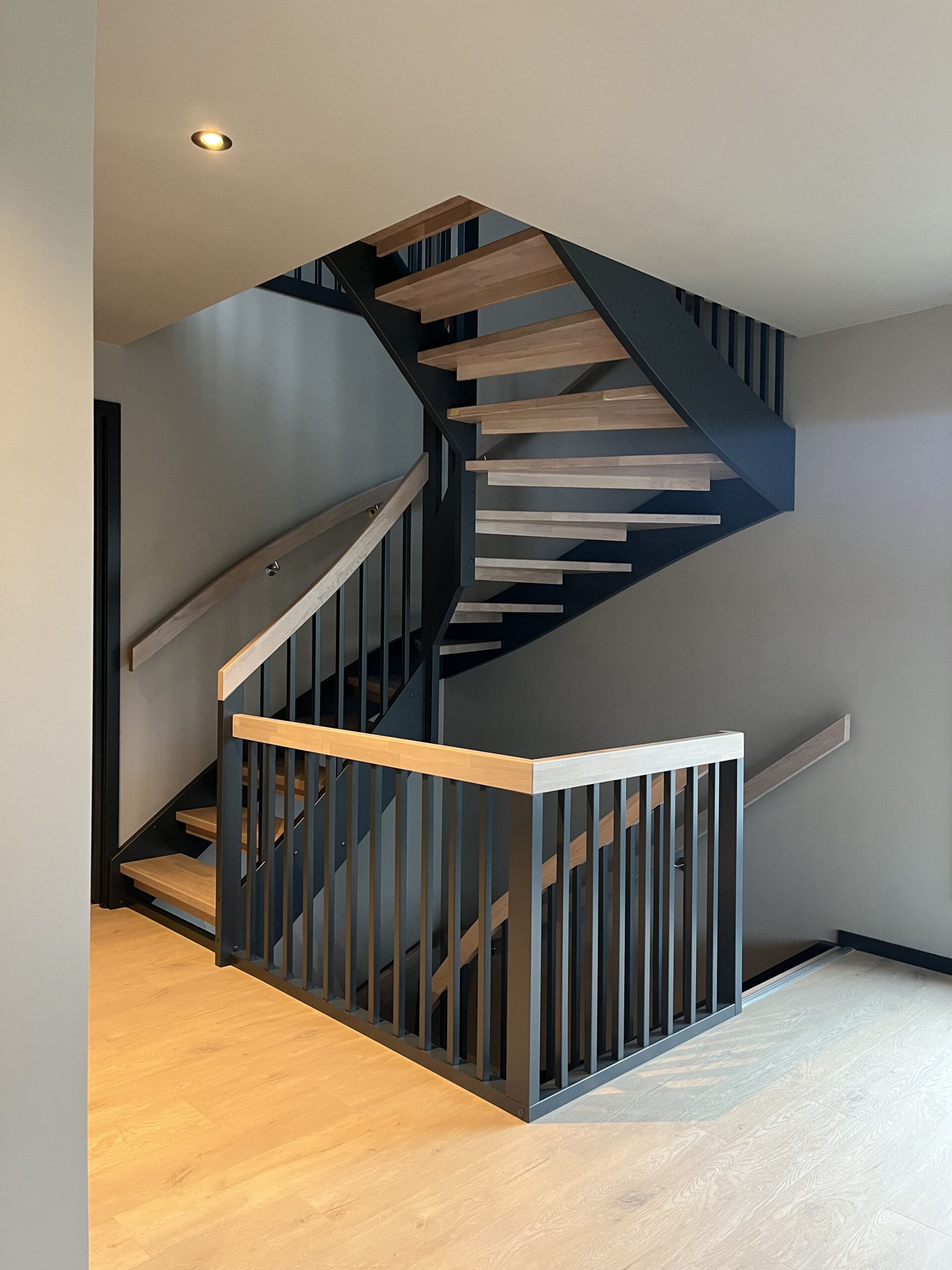 Schwarze Treppe mit Eichenstufen und Handläufen mit eckigen Balustern